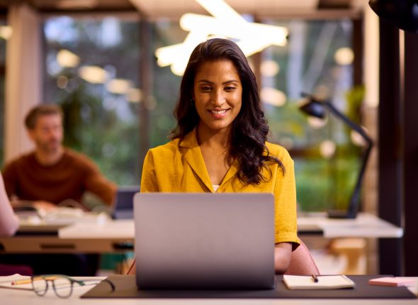 Mature Businesswoman Working On Laptop At Desk In Office